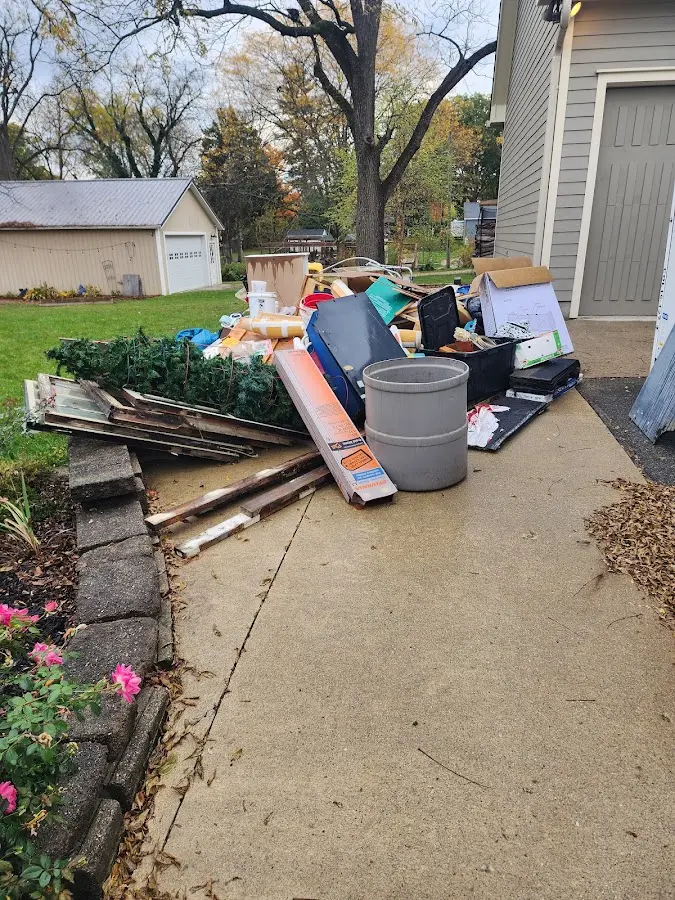 Dumpster being loaded with debris for 12 Yard Dumpster Rental in Grosse Pointe Woods